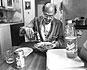 Allen pours Rice milk over cereal, Walt Whitman over his shoulder. 1992.